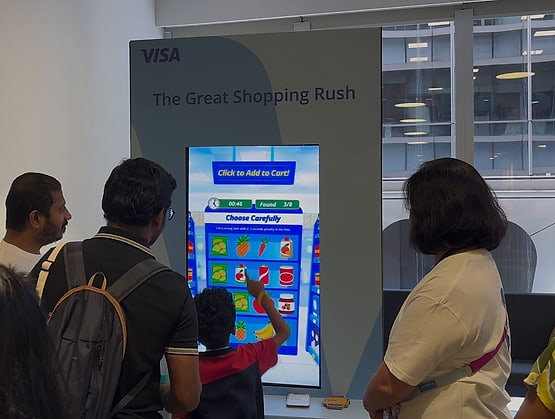 A boy tapping items on the screen at The Great Shopping Rush station by Paper Carpenter at Visa Family Day, run on qiksense