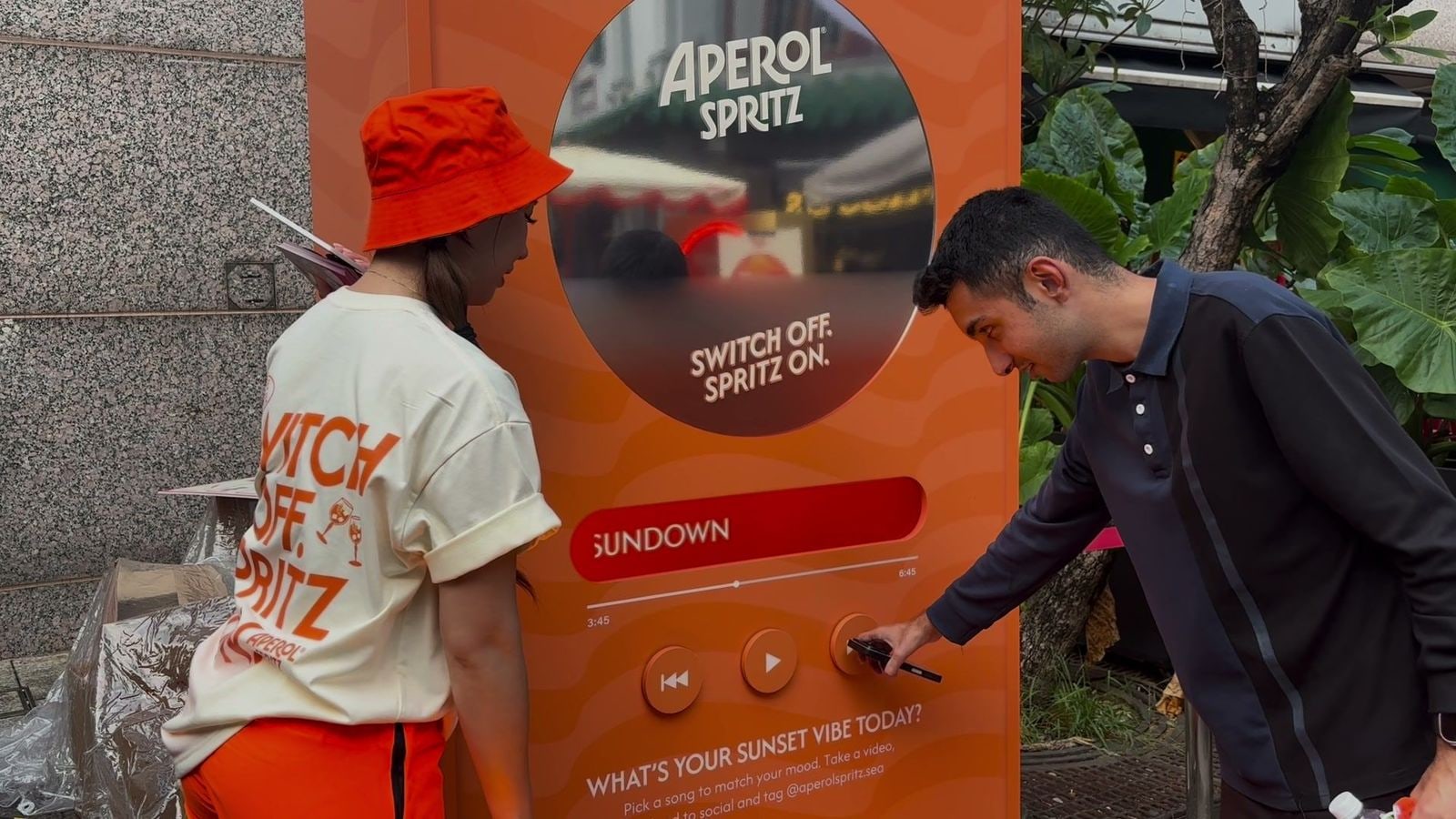 A guest pressing the next button on the Sunset Vibe music booth to pick the Sundown vibe on the qiksense music player