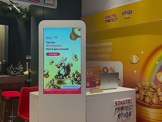 Singtel Protect and Etiqa counter inside a Singtel Shop, with the kiosk running the qiksense reward game