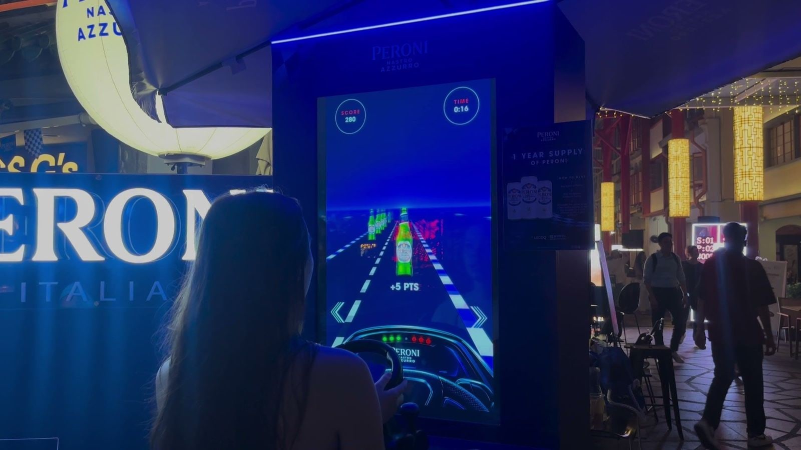 A guest steering past Peroni bottles on the road in the Speed Collector racing game run on qiksense