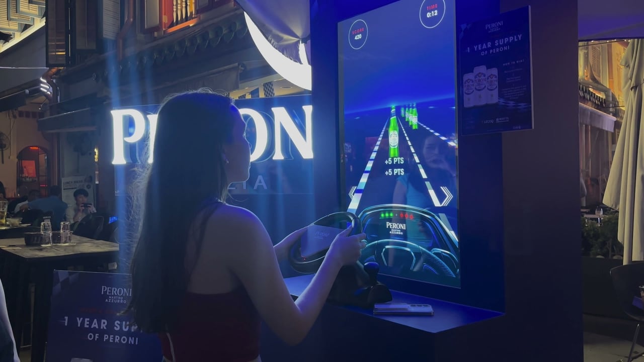 A guest collecting Peroni bottles on the road with the racing wheel