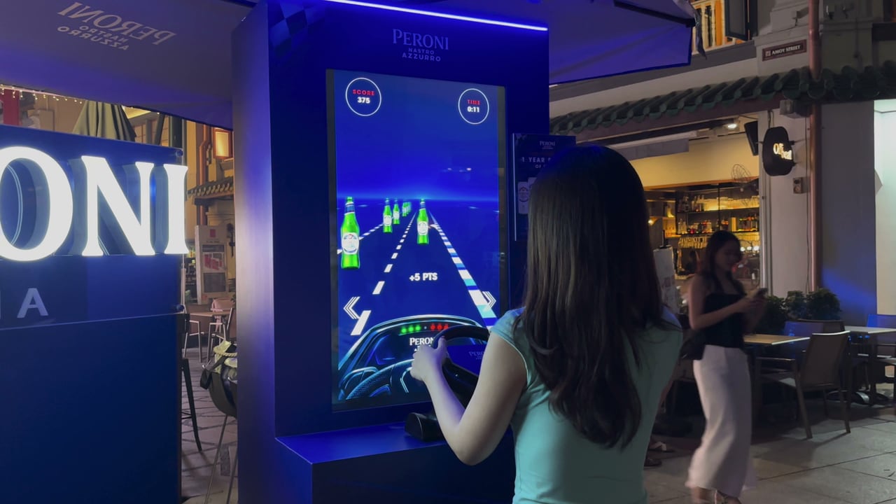 A guest steering the racing wheel at the Peroni Speed Collector