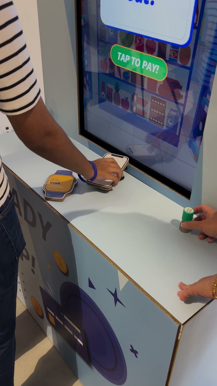 Tapping the cardboard Visa phone on the card reader